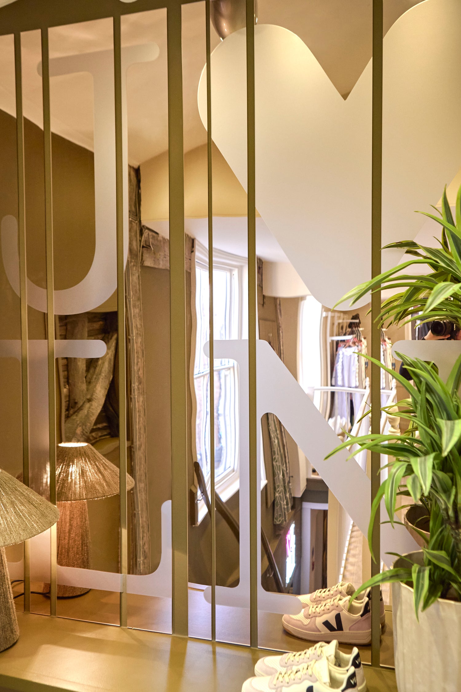 Modern retail interior design. Bespoke tinted mirror strips feature with etched branding.