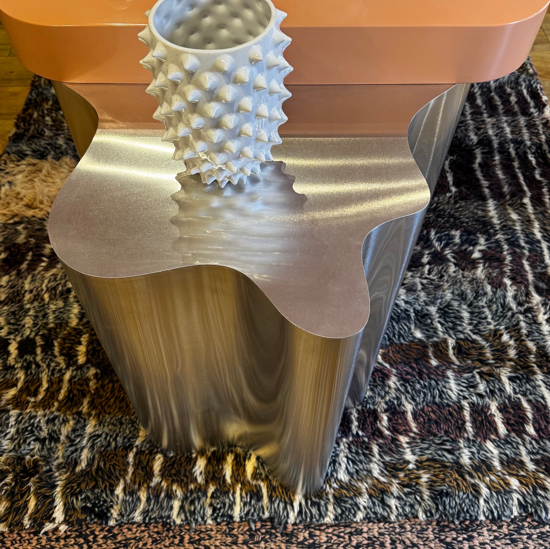 Bespoke table designed by House of Bo. Wavy metal leg. High gloss table top. Moroccan rug.