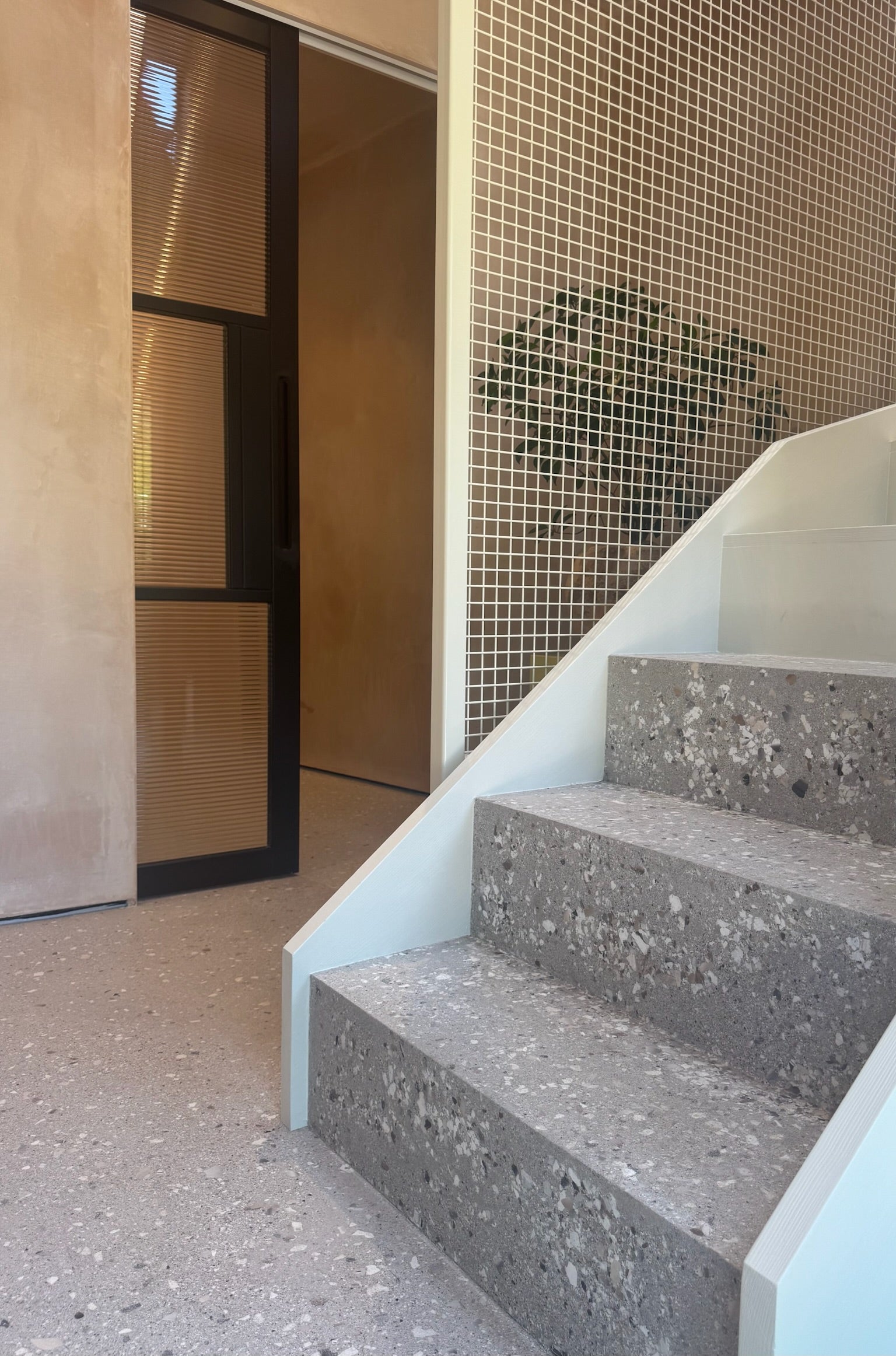 Microcement floor by Medusa Stucco, beautiful raw plaster walls, metal grid staircase design by House of Bo