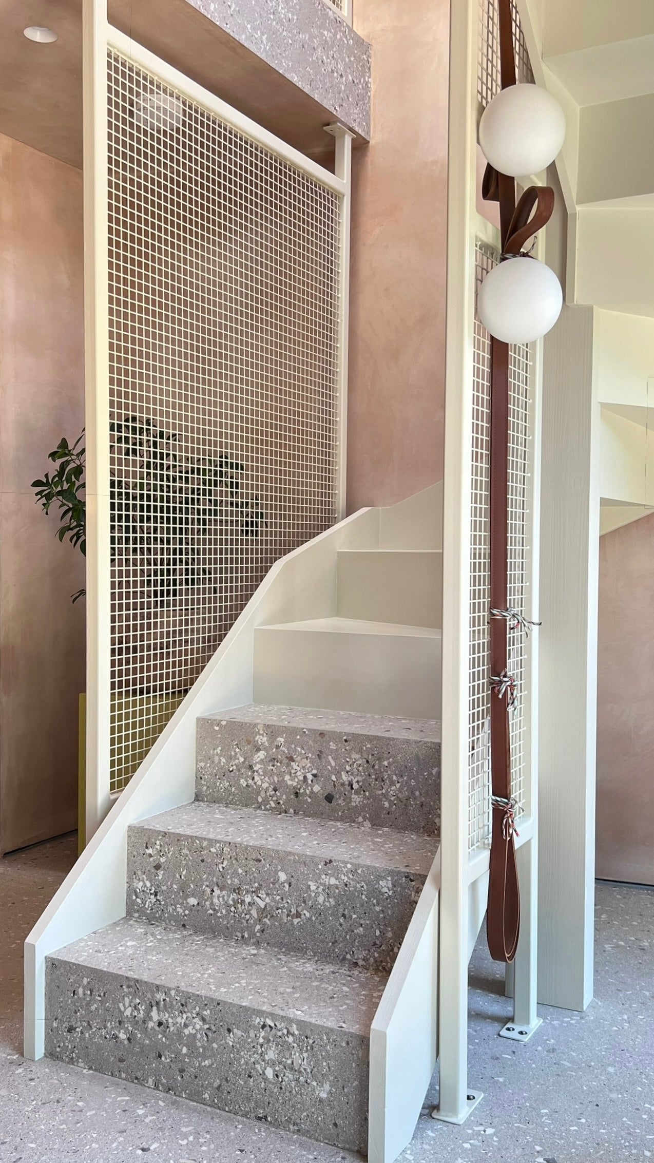 Contemporary lighting design using leather straps with clip-on glass frosted light globes. Microcement floor ledge